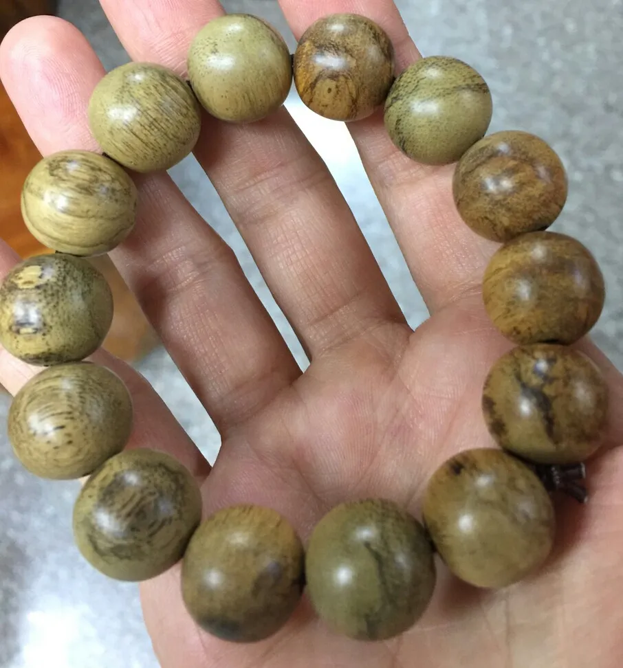 What is meant by the ability of agarwood prayer beads to float or sink in water?