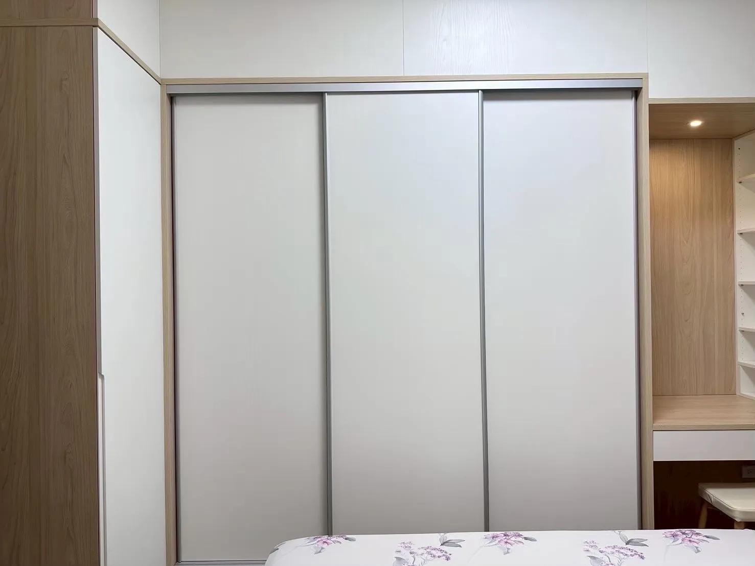 臥室到頂滑門衣櫃設計，霧面門板減少指紋與水痕，上方無落塵空隙，提升收納效率並降低清潔負擔的自住型室內設計案例。