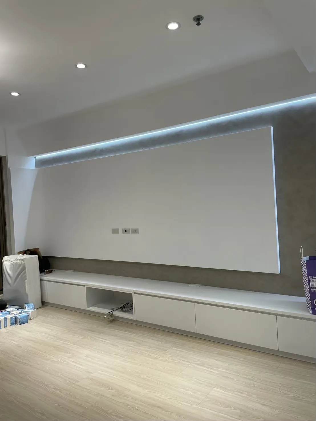 現代住宅電視牆設計，運用中性色牆面材質與隱藏式間接照明，減少高價建材使用，以材質選擇與燈光層次提升空間質感，兼顧美觀與裝潢預算。