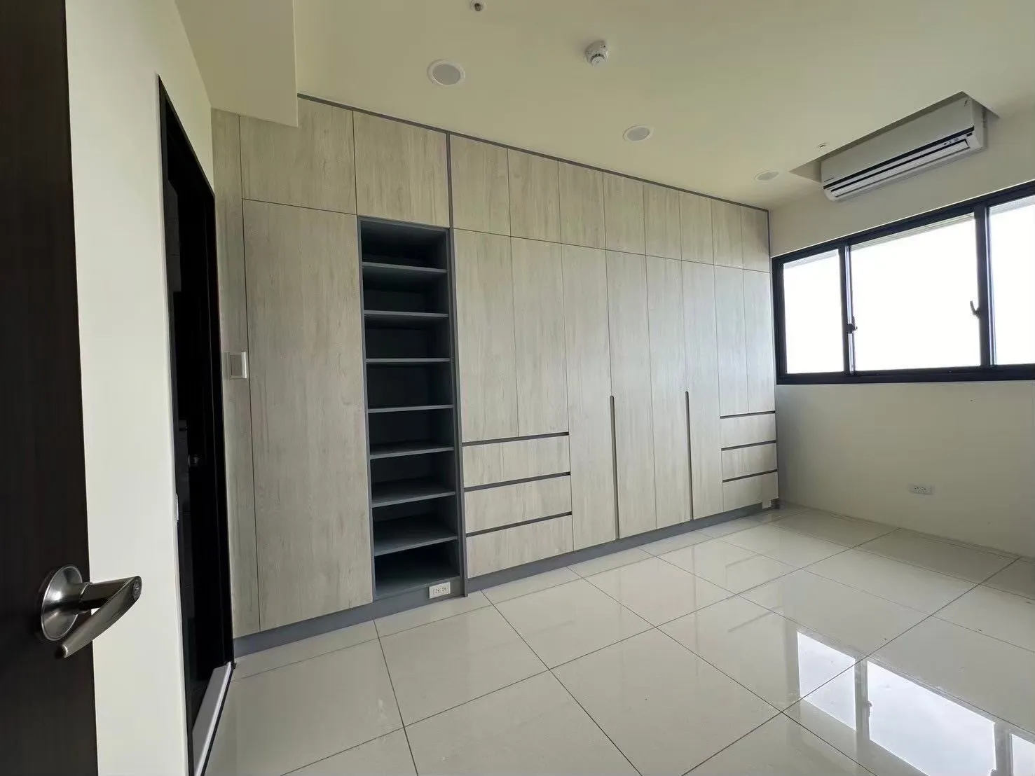 臥室整面系統櫃空間設計示意,木紋門片搭配抽屜與開放層架,呈現系統櫃收納規劃與立面整合效果。