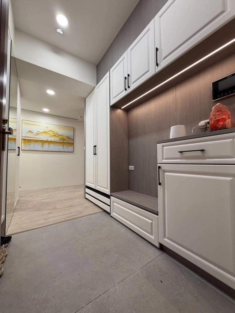 玄關收納設計範例，隱藏收納櫃體結合座椅與間接照明，提升小空間機能與整體整潔感