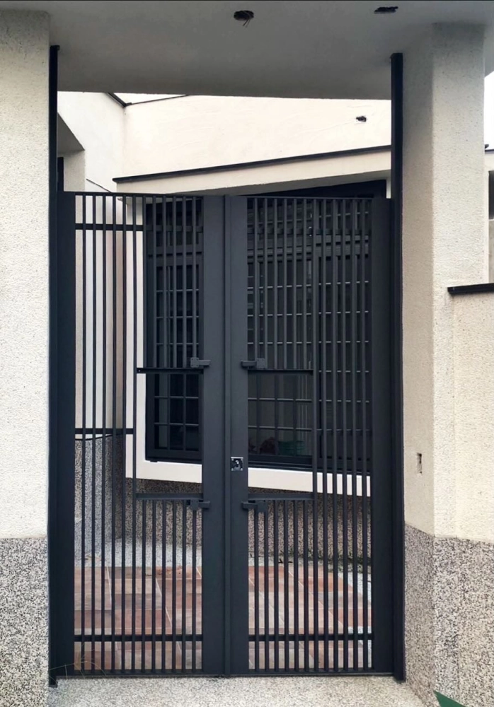 台中北屯｜不銹鋼直柵式住家入口大門-本案位於台中北屯，採不銹鋼直柵式大門設計，兼顧通風、採光與防護需求，搭配沉穩深色烤漆，展現現代住宅入口的大器與安全感。