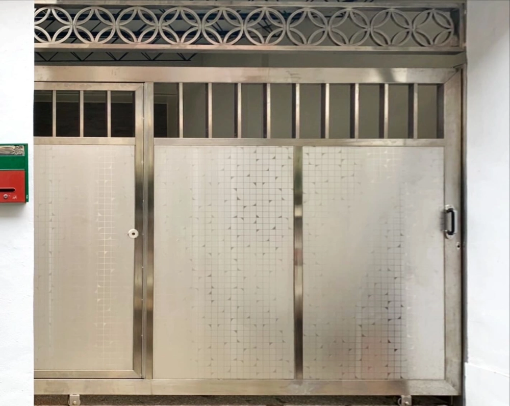 台中潭子｜不銹鋼霧面板住家入口大門-本案位於台中潭子，採用不銹鋼霧面板大門設計，結合上方通風欄與圓環造型元素，兼顧隱私、防護與耐用性，呈現實用且耐看的住宅入口風格。