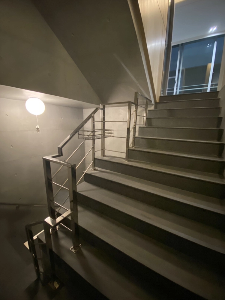 苗栗三義｜白鐵造型不銹鋼樓梯扶手-本案位於苗栗三義，採白鐵造型不銹鋼樓梯扶手設計，線條俐落、結構穩固，搭配室內清水模牆面，提升整體空間質感與行走安全性。