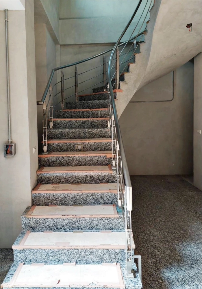 新竹東區｜白鐵造型不銹鋼樓梯扶手-本案位於新竹東區，採用白鐵造型不銹鋼樓梯扶手，線條流暢、弧形轉折自然，搭配石材階梯，兼顧結構安全與現代空間美感。